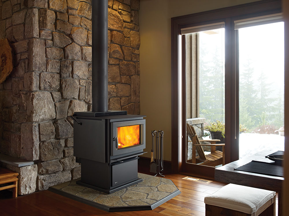 Free standing wood stove by window.